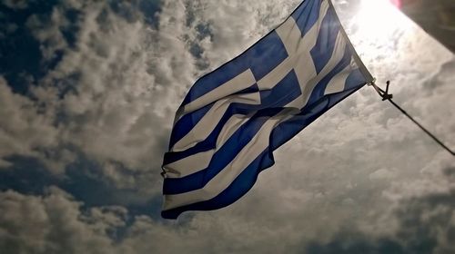 Low angle view of flag against blue sky