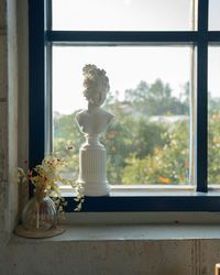 Close-up of statue on window sill