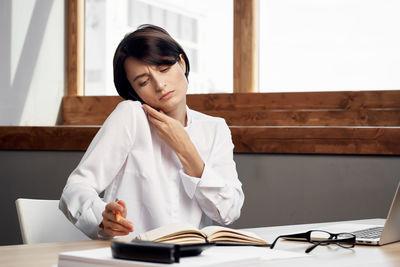 Businesswoman talking on phone while working at office