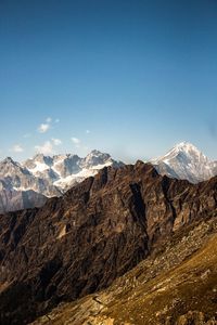 Scenic view of snowcapped mountains against blue sky