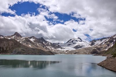 Calm lake against rocky mountain range