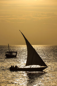 Silhouette sailboat on sea against sky during sunset