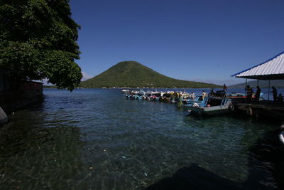 People on boat in sea against clear sky