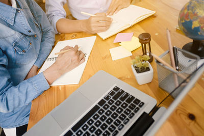 High angle view of people working on table at home
