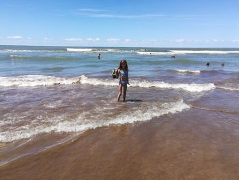 Full length of woman on beach against sky