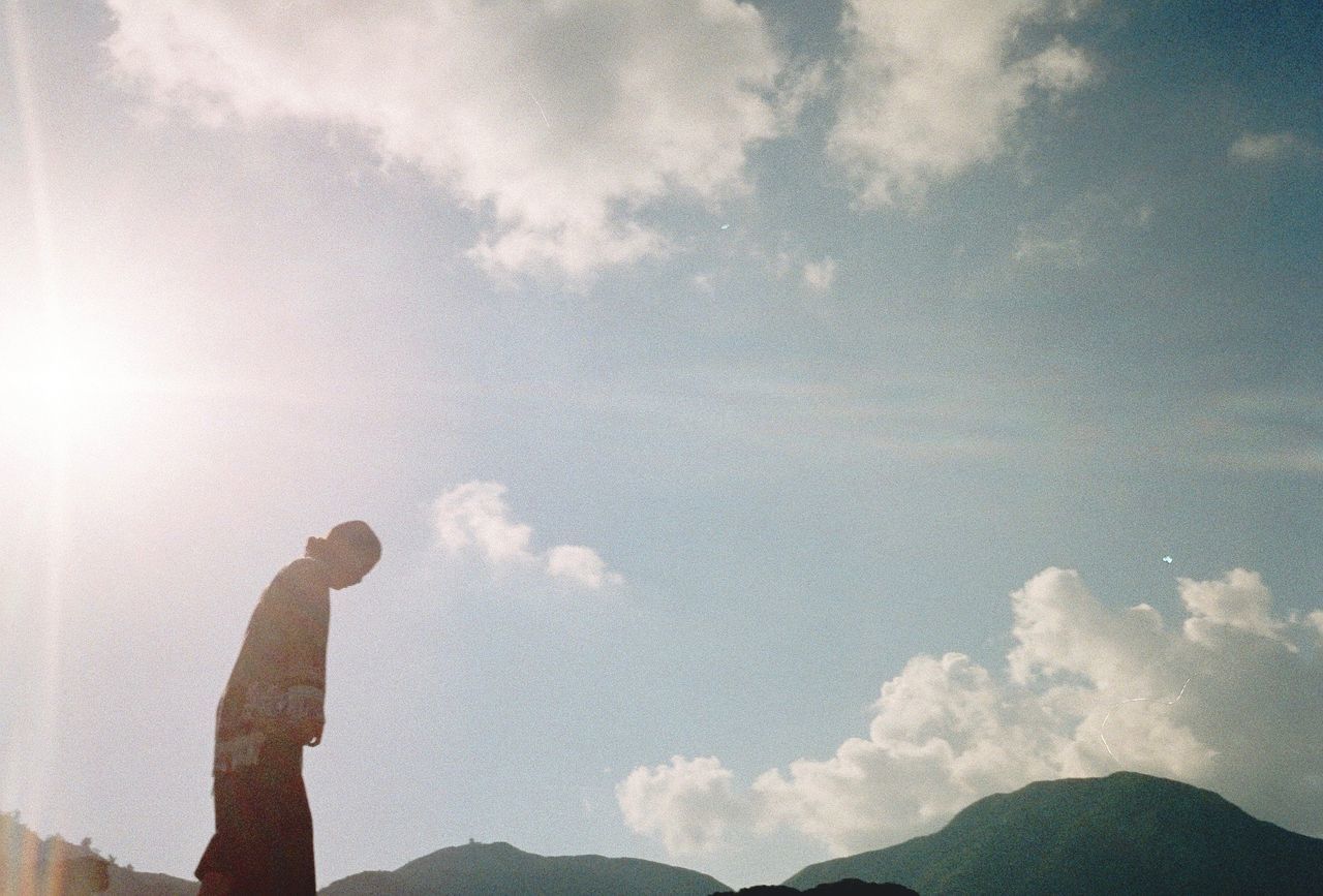 LOW ANGLE VIEW OF SILHOUETTE PERSON STANDING AGAINST SKY