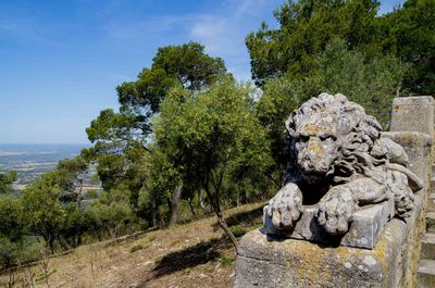 Statue amidst trees against sky