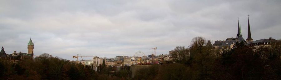 Buildings in city against cloudy sky