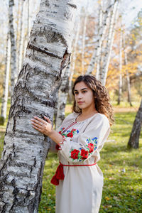 Beautiful woman in national ukrainian national traditional costume clothes walking in forest