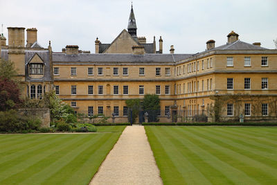 Lawn by building against sky