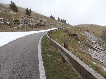 Road leading towards mountain against sky