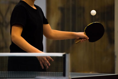 Midsection of man playing table tennis