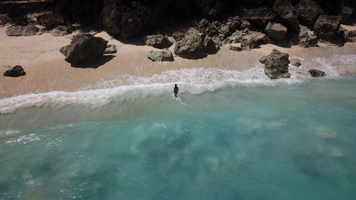 Aerial view of woman standing at sea