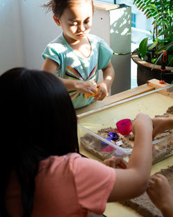 High angle view of siblings playing with toys