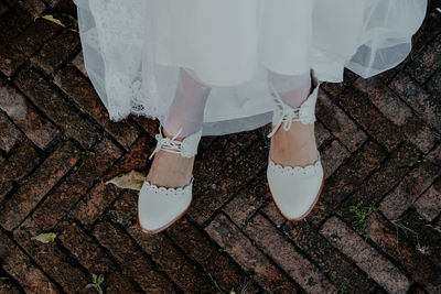 Low section of woman standing on footpath
