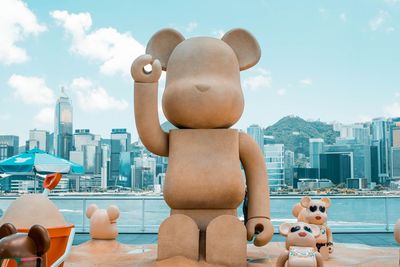 Stuffed toy by swimming pool against buildings in city