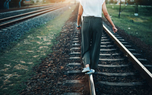 Low section of man standing on railroad track