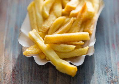 Close-up of french fries in paper plate on table