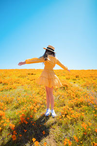 Woman standing on field against sky