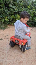 Boy sitting on toy car