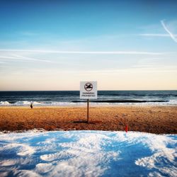 Scenic view of beach against cloudy sky