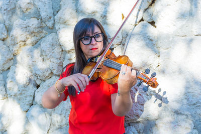 Portrait of teenage girl playing on wall