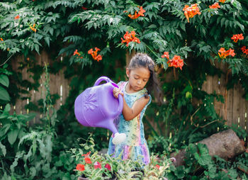 Portrait of young woman blowing flowers