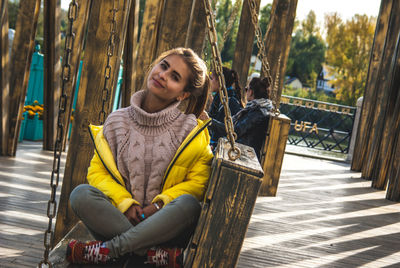 Portrait of smiling young woman sitting outdoors