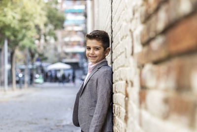 Portrait of boy standing against wall