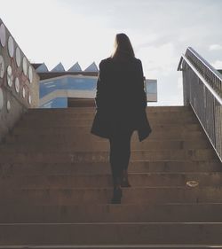 Low angle view of woman standing on stairs