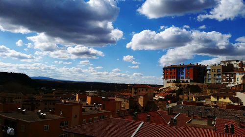 Buildings in town against cloudy sky