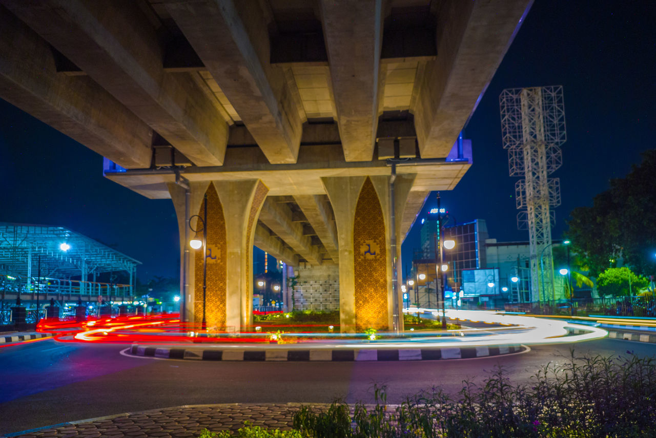 Illuminated bridge over city at night