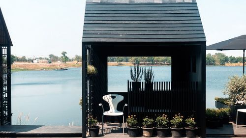 Potted plants by lake against sky