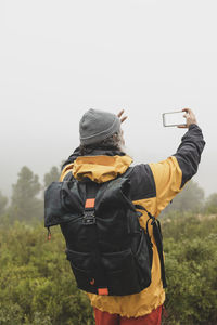 Hiker taking a selfie portrait in the mountain on a foggy day- hiking