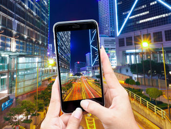 Midsection of man using mobile phone in city