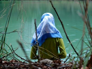 Rear view of woman in hijab at lake