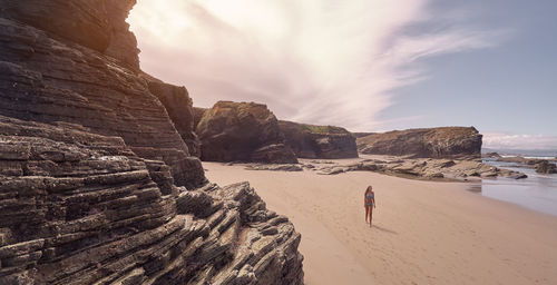 High angle view of woman walking on beach against sky