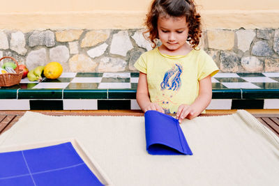 Girl folding napkin at home