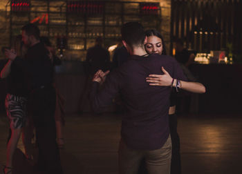 Couple kissing in illuminated city at night