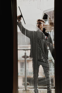 Young man looking through window