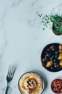 Hummus, and mixed olives on a marble background