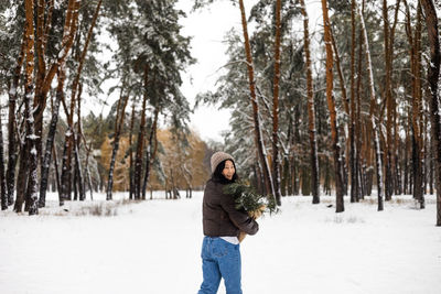 Rear view of woman standing on snow covered landscape