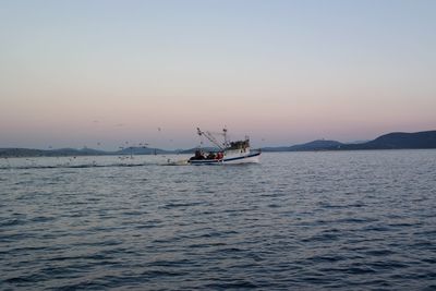 Fishing boat at sea against sky