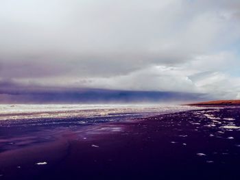 Scenic view of sea against storm clouds