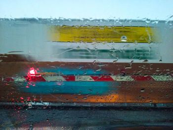 Close-up of wet car against sky during rainy season