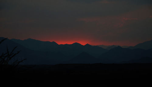 Scenic view of silhouette mountains against sky at sunset