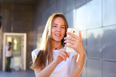 Portrait of smiling young woman drinking glass