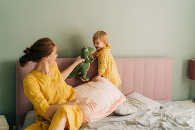 Mom and little daughter play toys at home.