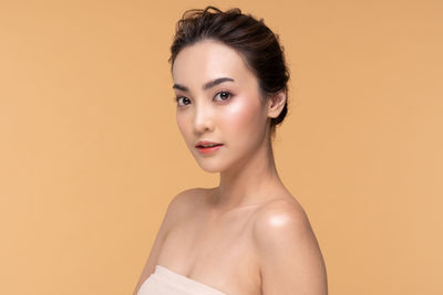 Portrait of young woman against gray background