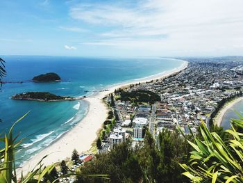 High angle view of town by sea against sky